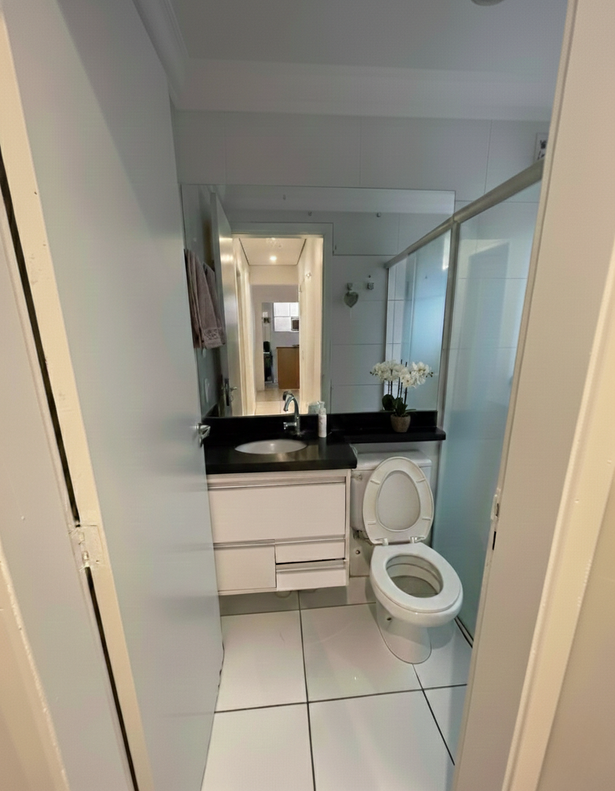 Banheiro social moderno com gabinete branco, duas portas, três gavetas sendo uma grande e nicho com porta basculante, bancada preta e acabamentos contemporâneos