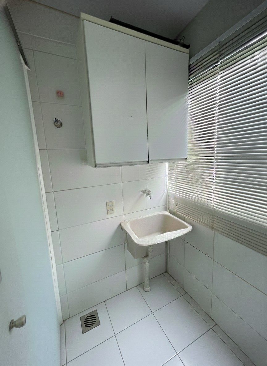 Área de serviço funcional com armário, separada por vidro blidex com porta de correr e persiana de inox