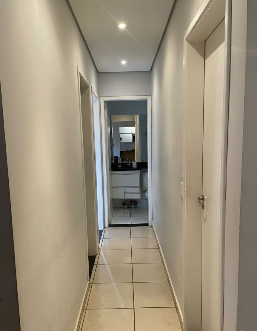 Corredor de acesso aos quartos com teto rebaixado em luzes de led criando uma atmosfera sofisticada e moderna