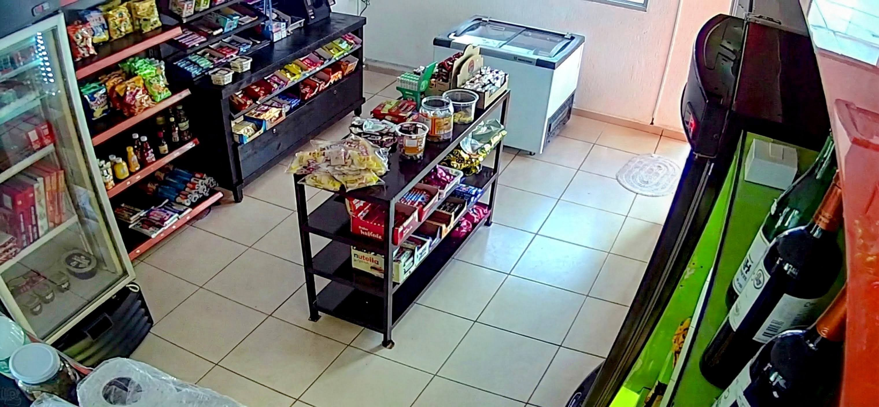 Mercado autônomo 24 horas mostrando prateleiras com produtos diversos, coolers refrigerados e sistemas automatizados de pagamento para praticidade sem sair do condomínio